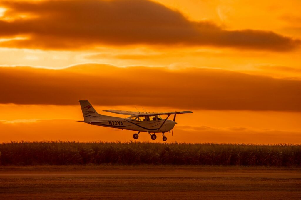 夕焼けを背景に飛ぶセスナ機
