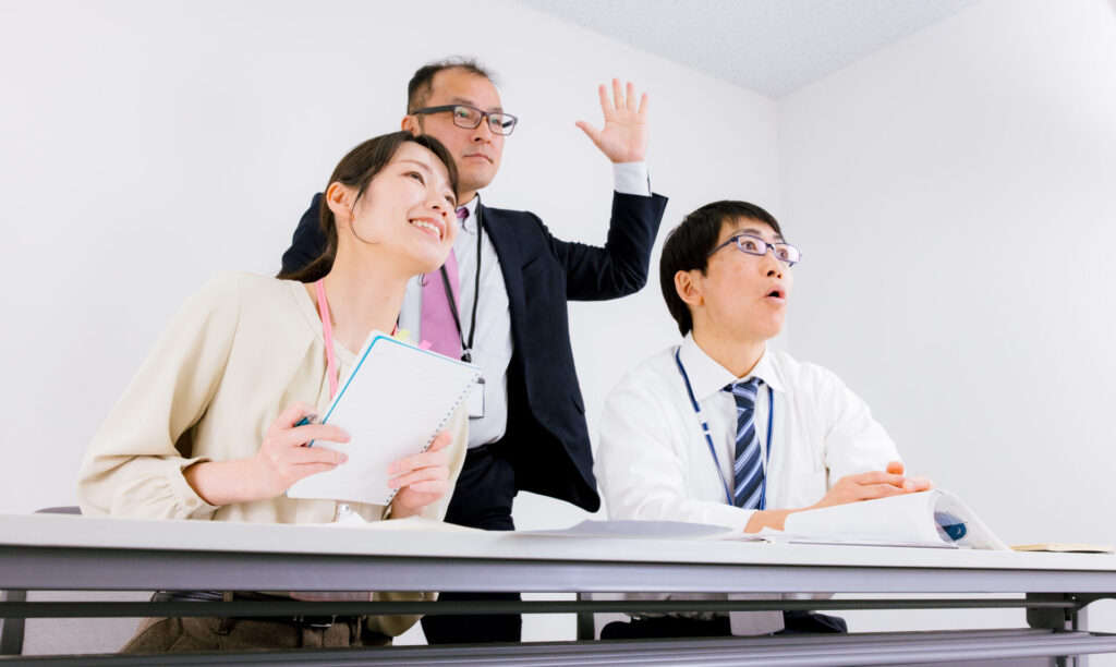 挙手して質問する3人の受講生