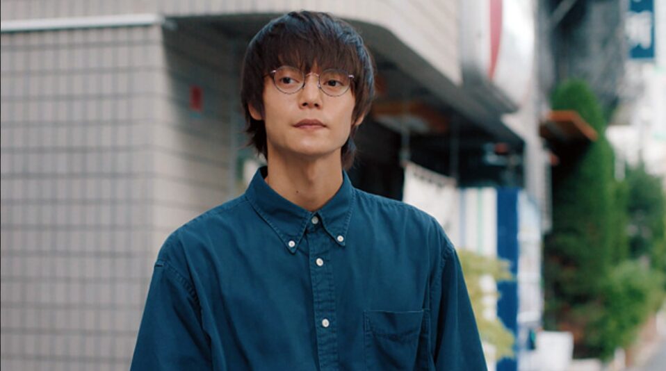 街頭のロケで無表情を演じている若い男性俳優