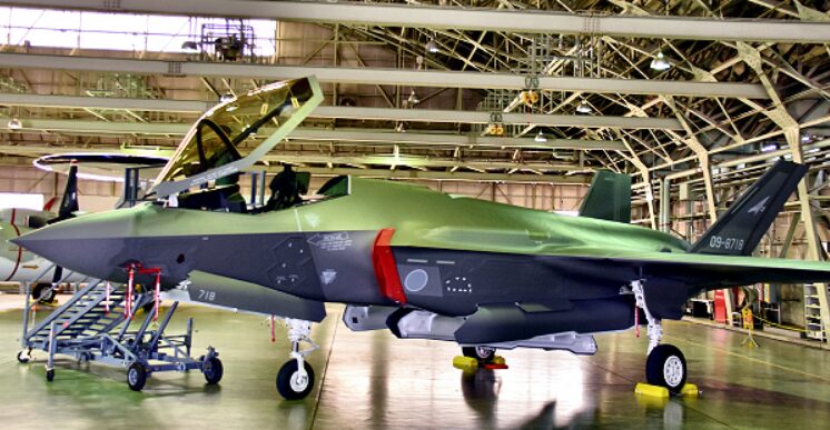 工場の格納庫で新型戦闘機の機体整備をする