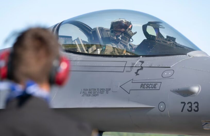 ハンドサインを交わす戦闘機パイロットと整備員