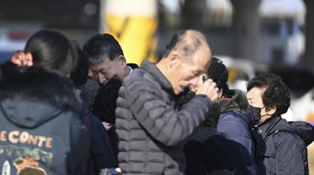 航空事故の遺体確認を終えた遺族たち