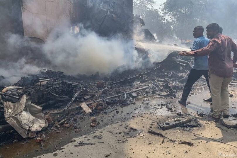 旅客機が空港近くの住宅街に墜落した現場で作業する消防士ら