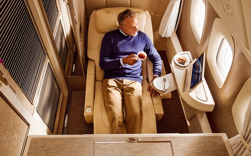 ファーストクラスの座席でくつろぐ男性旅行客